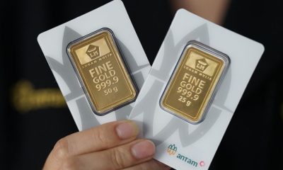 Harga emas Antam 999,9 dengan berat 50 g dan 25 g dipegang tangan.