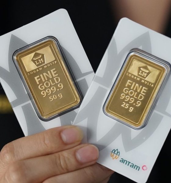 Harga emas Antam 999,9 dengan berat 50 g dan 25 g dipegang tangan.