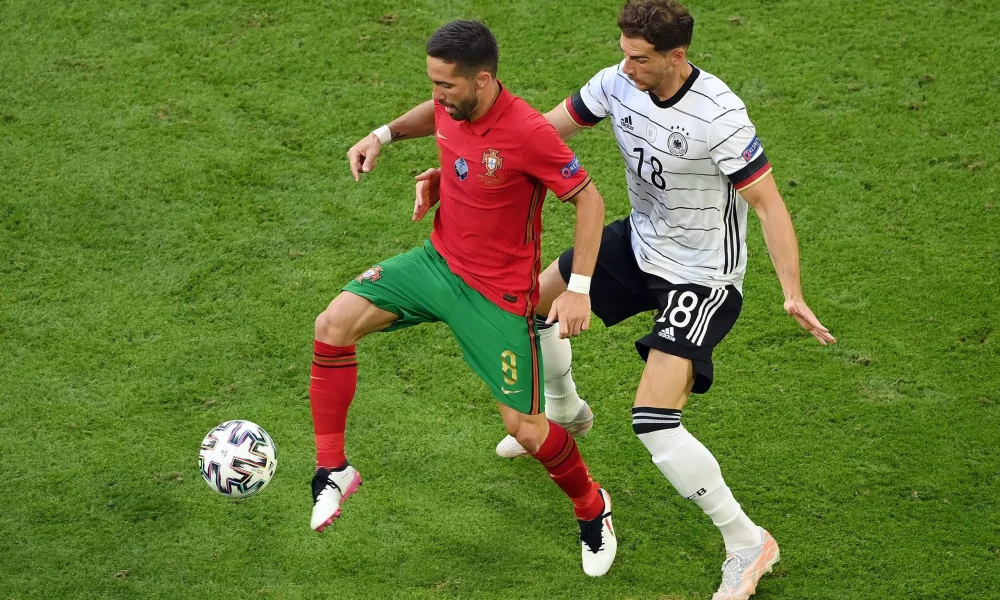 Dua tim nasional Eropa bersiap memulai pertandingan sepak bola di stadion besar dengan atmosfer penonton meriah.