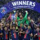 Skuad PSG mengangkat trofi Liga Champions 2025 di Allianz Arena, dikelilingi konfeti kemenangan.