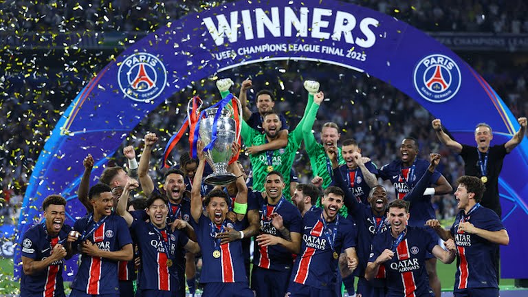Skuad PSG mengangkat trofi Liga Champions 2025 di Allianz Arena, dikelilingi konfeti kemenangan.