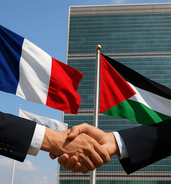 Bendera Prancis dan Palestina berkibar berdampingan di depan markas PBB, diapit jabat tangan diplomat—momen simbolis “Prancis Akui Palestina”.